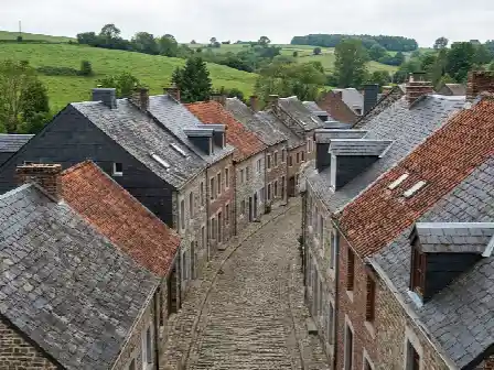 Rue de village wallon mêlant toitures en ardoises et en tuiles